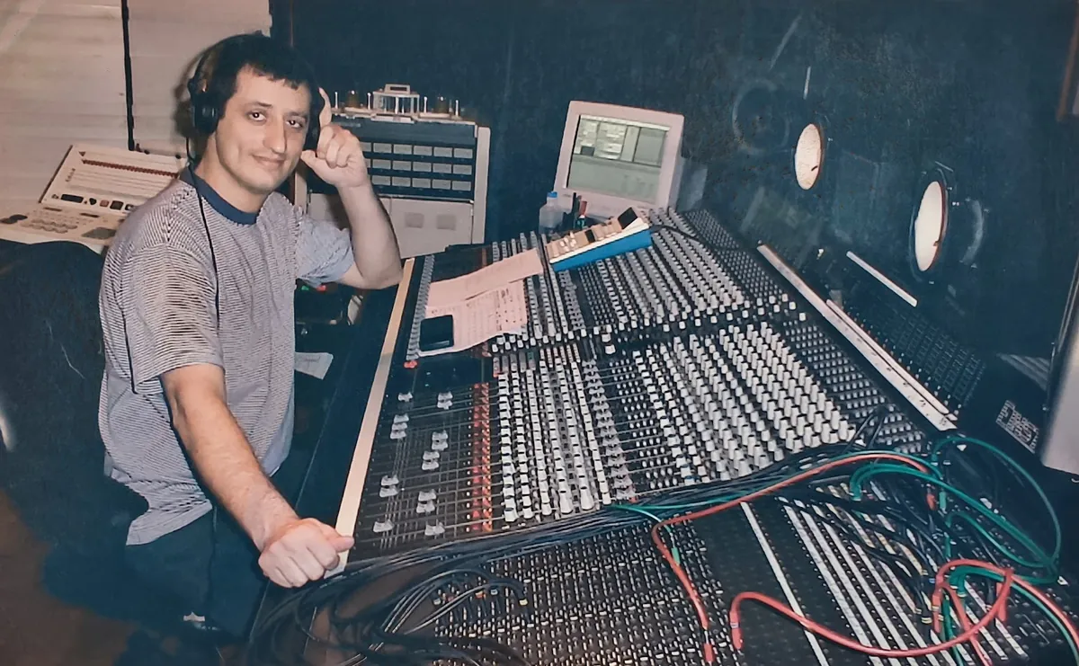 Néstor Randazzo with headphones at a large analog studio console